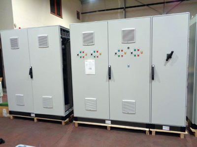 Armario eléctrico con luces de control, interruptores giratorios, dispositivos de medición y rejillas de ventilador instaladas en el panel frontal, realizado con una punzonadora CT2 y/o cortadoras de piezas Grangier.